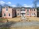 Elegant brick home boasts white trim, arched windows, a fountain, and lush landscaping at 10 Club Ct, Alpharetta, GA 30005