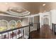 Upper hallway with decorative railing and chandelier offers backyard view from the tall window at 10 Club Ct, Alpharetta, GA 30005