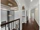 Hallway featuring hardwood floors, decorative arches, and wrought iron staircase at 10 Club Ct, Alpharetta, GA 30005