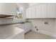 Well-lit laundry room featuring white cabinets and plenty of counter space for folding and organizing laundry at 10 Club Ct, Alpharetta, GA 30005