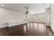 Large living room featuring hardwood floors, crown molding, modern chandeliers, and built-in cabinets at 10 Club Ct, Alpharetta, GA 30005