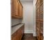 Pantry with custom wood cabinets, dark hardwood floors and gray countertops at 10 Club Ct, Alpharetta, GA 30005