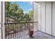 Outdoor balcony with wood-look tile and black railings, offering scenic views of mature trees and blue skies at 1199 Huff Rd # 121, Atlanta, GA 30318