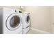 Well-lit laundry room featuring modern front-load washer and dryer units with wire shelving above at 1199 Huff Rd # 121, Atlanta, GA 30318