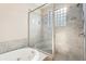 Modern glass-enclosed shower and luxurious built-in bathtub with tiled surround at 1199 Huff Rd # 121, Atlanta, GA 30318