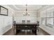 A dining room featuring a chandelier, decorative molding, and a dark wood table with bench seating at 4270 Pleasant Woods Dr, Cumming, GA 30028