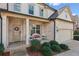 Inviting front porch with brick accents, seating area, and a charming front door with a wreath at 4270 Pleasant Woods Dr, Cumming, GA 30028