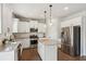 Bright kitchen featuring white cabinets, stainless steel appliances, granite countertops, and hardwood flooring at 4270 Pleasant Woods Dr, Cumming, GA 30028