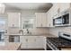 Well-lit kitchen boasting white cabinets, granite countertops, stainless steel appliances, and stylish backsplash at 4270 Pleasant Woods Dr, Cumming, GA 30028