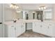 The main bathroom featuring dual sinks, white cabinets, and a large mirror at 4270 Pleasant Woods Dr, Cumming, GA 30028