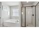 A main bathroom featuring a soaking tub, a shower with glass door, and a window at 4270 Pleasant Woods Dr, Cumming, GA 30028