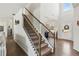 Elegant staircase with carpeted steps, iron railings, and natural light flowing through the high ceiling at 4270 Pleasant Woods Dr, Cumming, GA 30028