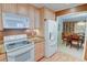 Open kitchen featuring modern appliances and light wood cabinets, with a view to dining area at 500 Bainbridge Dr, Atlanta, GA 30327