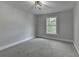This bedroom has neutral paint, plush carpet and a large window for natural light at 1887 Lake Ridge Ter, Lawrenceville, GA 30043