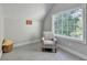 A bonus room is brightened by a large window and filled with neutral-colored walls and carpet at 1887 Lake Ridge Ter, Lawrenceville, GA 30043