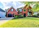 Stunning two-story red brick home with a well-manicured lawn, lush landscaping, and attached two-car garage at 1887 Lake Ridge Ter, Lawrenceville, GA 30043