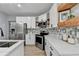 Well-appointed kitchen offers stainless appliances, white cabinets, quartz countertops, and stylish backsplash at 1887 Lake Ridge Ter, Lawrenceville, GA 30043