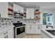 Bright kitchen features stainless appliances, quartz countertops, and modern cabinetry with open shelving at 1887 Lake Ridge Ter, Lawrenceville, GA 30043