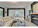 Cozy living room featuring a large sectional sofa, modern fireplace, and access to sunroom, perfect for relaxing at 1887 Lake Ridge Ter, Lawrenceville, GA 30043