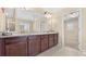 Bathroom features a long granite countertop, dark wood cabinets, and a large mirror and lighting at 2040 Bloomfield Ct, Cumming, GA 30041