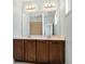 Double vanity with dark wood cabinets, white countertops, a large mirror, and modern fixtures at 3066 Quantum Ln # 24, Atlanta, GA 30341