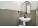 Chic powder room features modern black mirror, pedestal sink, and neutral two-tone wall paint at 3066 Quantum Ln # 24, Atlanta, GA 30341