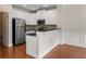 Cozy kitchen features white cabinets, stainless steel appliances, and breakfast bar with dark granite countertops at 3066 Quantum Ln # 24, Atlanta, GA 30341