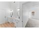 Bathroom with dual sinks and wood-look flooring leading to a bedroom at 3529 Riverview Approach, Ellenwood, GA 30294