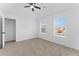Cozy bedroom with a modern ceiling fan, soft carpeting, and well-lit windows for natural light, enhancing comfort at 3529 Riverview Approach, Ellenwood, GA 30294