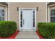 Inviting entryway with white front door framed by sidelights and lush landscaping at 3529 Riverview Approach, Ellenwood, GA 30294