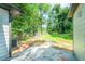 View of the backyard with lush lawn, mature trees, and stone patio at 1251 Richland Sw Rd, Atlanta, GA 30310
