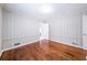 Bedroom featuring hardwood floors, paneled walls, and a window letting in natural light at 1251 Richland Sw Rd, Atlanta, GA 30310