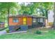 Charming home featuring a colorful front door, wood accents, and a well-maintained lawn with mature trees at 1251 Richland Sw Rd, Atlanta, GA 30310