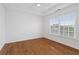 Neutral bedroom with wood floors, large window, and modern ceiling fan at 1711 Summit Glen Ln, Atlanta, GA 30329