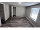 This bedroom features gray walls, grey wood floors, a window, and a closet at 3042 Humphries Hill Rd, Austell, GA 30106