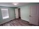 This bedroom features grey wood floors, a window, and a closet with ample space at 3042 Humphries Hill Rd, Austell, GA 30106