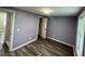 This bedroom features light purple walls, grey wood floors, and a window at 3042 Humphries Hill Rd, Austell, GA 30106