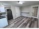 This compact kitchen features white cabinets, a stainless steel fridge, and grey wood floors at 3042 Humphries Hill Rd, Austell, GA 30106