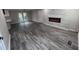 View of living room featuring gray wood floors, modern fireplace, and a view into an adjacent room at 3042 Humphries Hill Rd, Austell, GA 30106