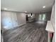 Living room view with gray wood floors, fireplace, and view into kitchen at 3042 Humphries Hill Rd, Austell, GA 30106