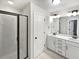 Modern bathroom featuring white cabinets, dual sinks, and a walk-in shower with glass doors at 3282 Spicy Cedar Ln, Lithonia, GA 30038