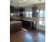 A kitchen showcasing dark wood cabinets, granite countertops, stainless steel appliances, and ample natural light at 8413 Members Dr, Jonesboro, GA 30236