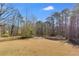 Large backyard featuring mature trees and a partially cleared space at 4094 Yancey Rd, Douglasville, GA 30135