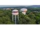 Aerial view of Cumming, GA water towers surrounded by lush greenery and cityscape in the background at 504 Healy Dr # 75, Cumming, GA 30040