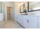Bright bathroom with white cabinets, double sink, decorative mirror and white marble tile floors at 504 Healy Dr # 75, Cumming, GA 30040