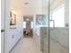 Bright bathroom featuring white cabinets, shower with glass doors, marble tile flooring and window at 504 Healy Dr # 75, Cumming, GA 30040