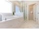 Elegant bathroom with a soaking tub, glass shower, and modern fixtures at 504 Healy Dr # 75, Cumming, GA 30040