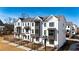 Stunning three-story townhome featuring brick facade, sleek black windows, and professional landscaping at 504 Healy Dr # 75, Cumming, GA 30040