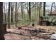 Backyard featuring a fire pit and wooded surroundings, perfect for outdoor gatherings at 1302 Buttercup Ct, Lawrenceville, GA 30044