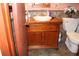 Bathroom vanity and toilet setup with wood cabinet and ceramic sink, offering practical elegance at 1302 Buttercup Ct, Lawrenceville, GA 30044